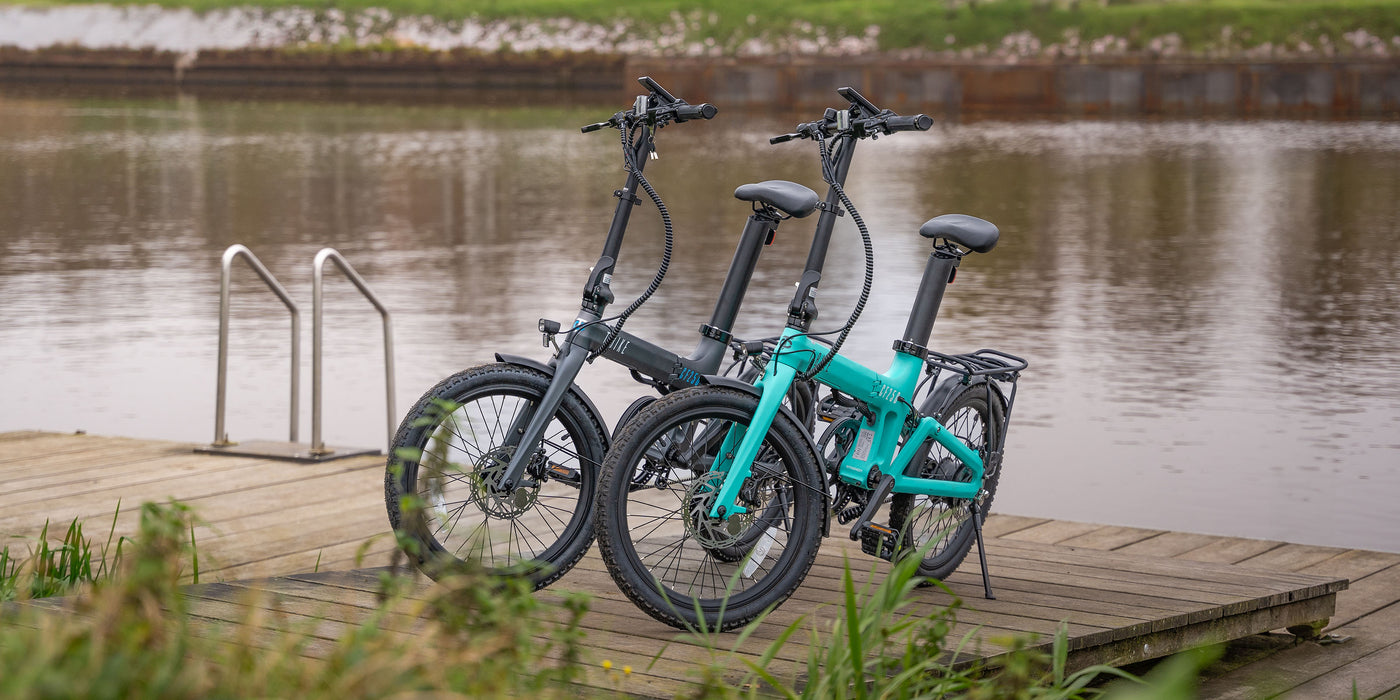 Image of the Black and turquoise Carbon Fibre 250 folding E-Bikes on a wooden dock
