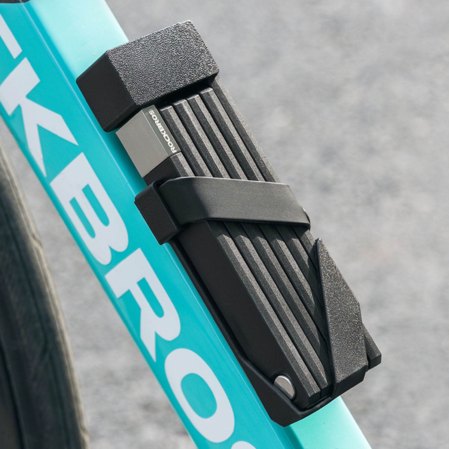 Image of a folding lock being attached to the frame of a bike for easy transportation