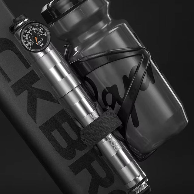 Image of the manual bike pump being attached to the bike alongside the frame mounted bottle holder